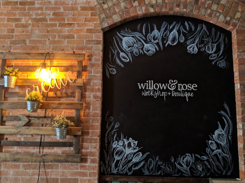 Hand-lettered Willow & Rose chalkboard wall on exposed brick